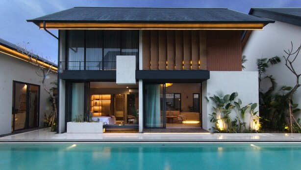 Una casa moderna con piscina, ventanas amplias y balcón.