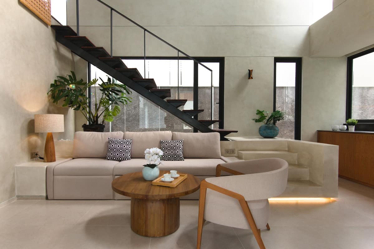 Ein modernes Wohnzimmer mit Sofa, Couchtisch und einer Treppe.