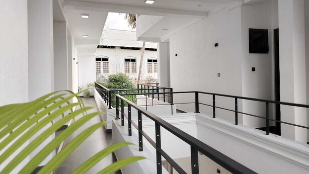 A modern interior with a staircase, white walls, and a view of the outside. - DIORA Hotel (Ratnapura)