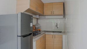 Een keuken met houten kastjes, een roestvrijstalen koelkast en een spoelbak.