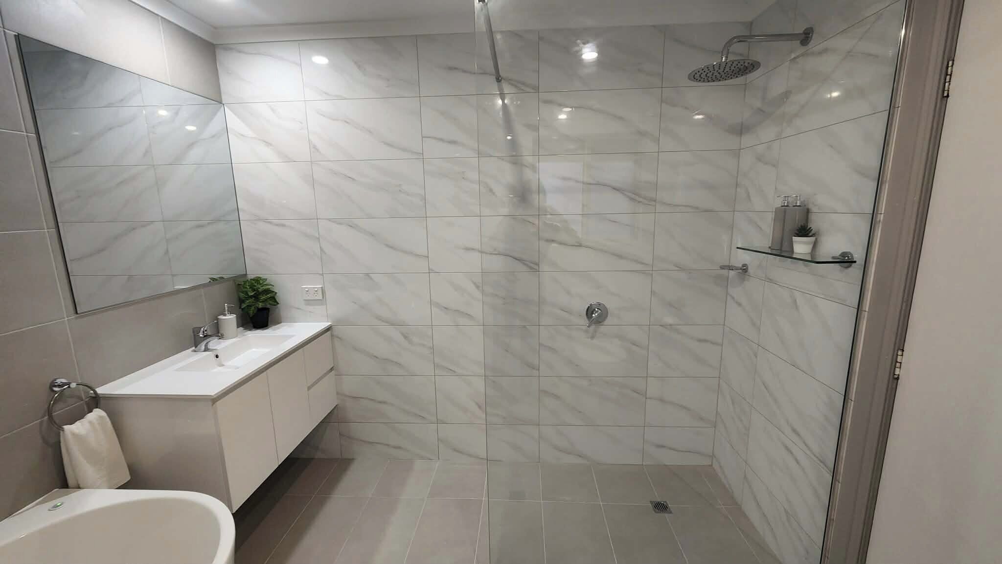 A modern bathroom with a shower, sink, and bathtub.