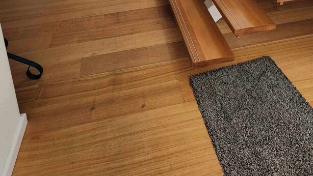 Una sala de estar moderna con una escalera de madera, una chimenea y un comedor.