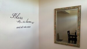 Un mur orné d’une plaque décorative sur laquelle on peut lire : « Que cette maison et tous ceux qui y entrent soient bénis. »