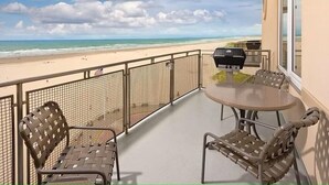 A balcony with a view of the beach, a grill, and two wicker chairs. - Oceanfront Penthouse Condo, Worldmark Seaside Resort; Nights 5, 6 & 7 only 50 (Seaside)