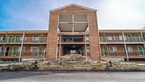 Un bâtiment en bois à deux étages, doté d’une entrée centrale et d’un escalier menant à cette entrée.