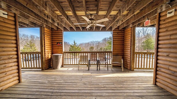 A wooden deck with a ceiling fan, a bench, and a trash can. - Modern in the Mountains | Free Shuttle to SDC (Branson)