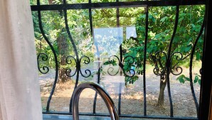 A bathroom with a window and a metal railing.