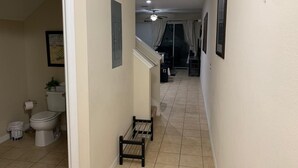 A narrow hallway with a toilet on the left, a staircase in the center, and a door at the end. - Charming 3-bedroom chalet with WiFi and AC in Kissimmee (Kissimmee)
