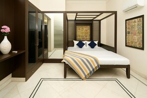 Une chambre à coucher comprenant un lit, une table de chevet, une armoire et un miroir.
