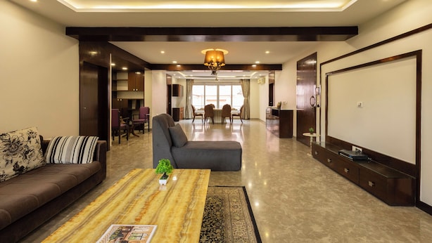 A modern living room with a sofa, coffee table, and a television. - Victoria Apartment by Jadecaps (Kolkata)