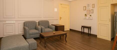 A room with a sofa set, a wooden coffee table, a small side table, and a cabinet.