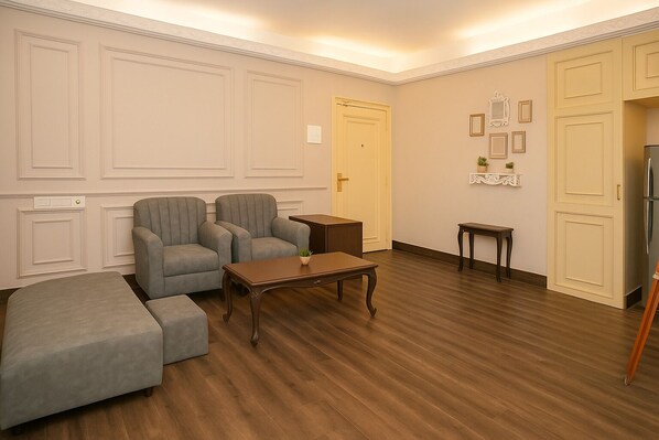 Una habitación con un sofá, una mesa de centro de madera, una mesita auxiliar y un armario.