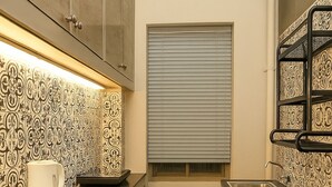 A compact kitchen with a countertop, a sink, and patterned backsplash. - Vivanta Apartment by Jadecaps (Kolkata)
