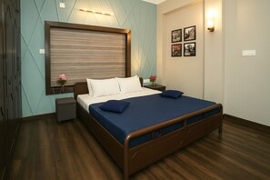 Un dormitorio ordenado con una cama, mesitas de noche y un aplique de pared.