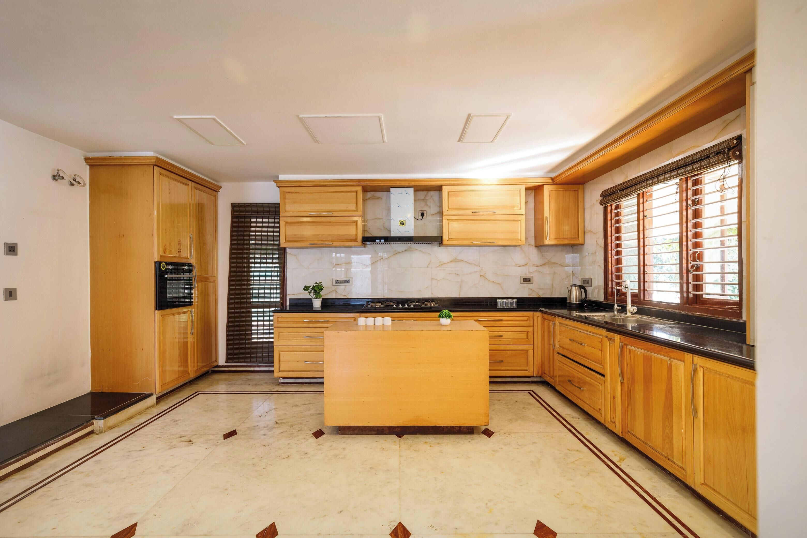 Una cocina moderna con armarios de madera, encimera de mármol y una isla central.