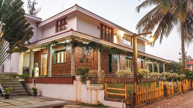 A two-story building with a balcony, a staircase, and a paved walkway. - Ananta Vilas by Stayjade (Bengaluru)
