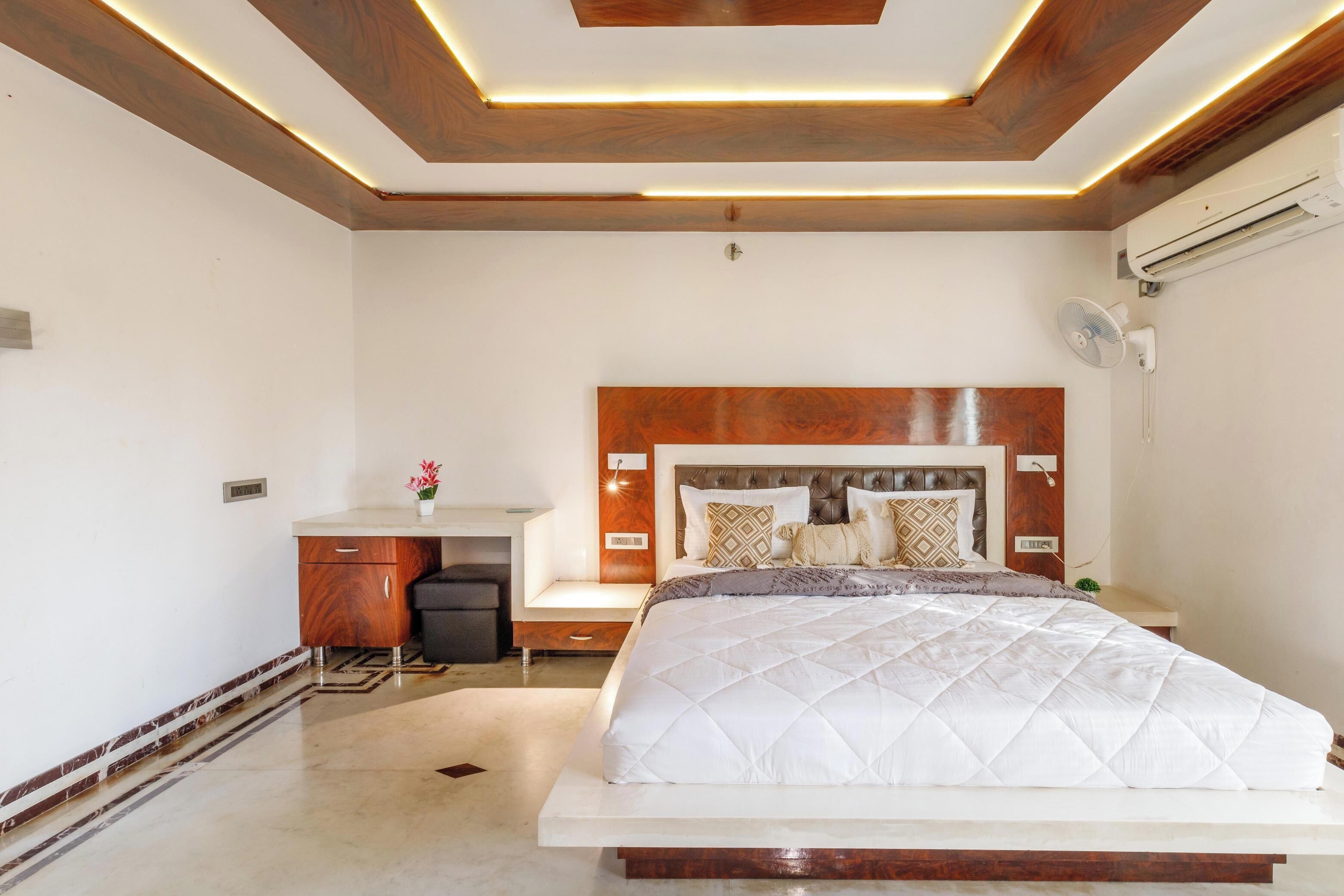A bedroom with a bed, bedside table, and a desk with a chair.