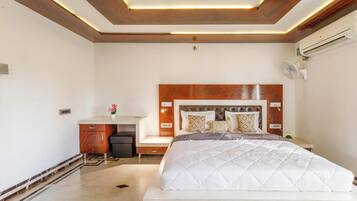 A bedroom with a bed, bedside table, and a desk with a chair.