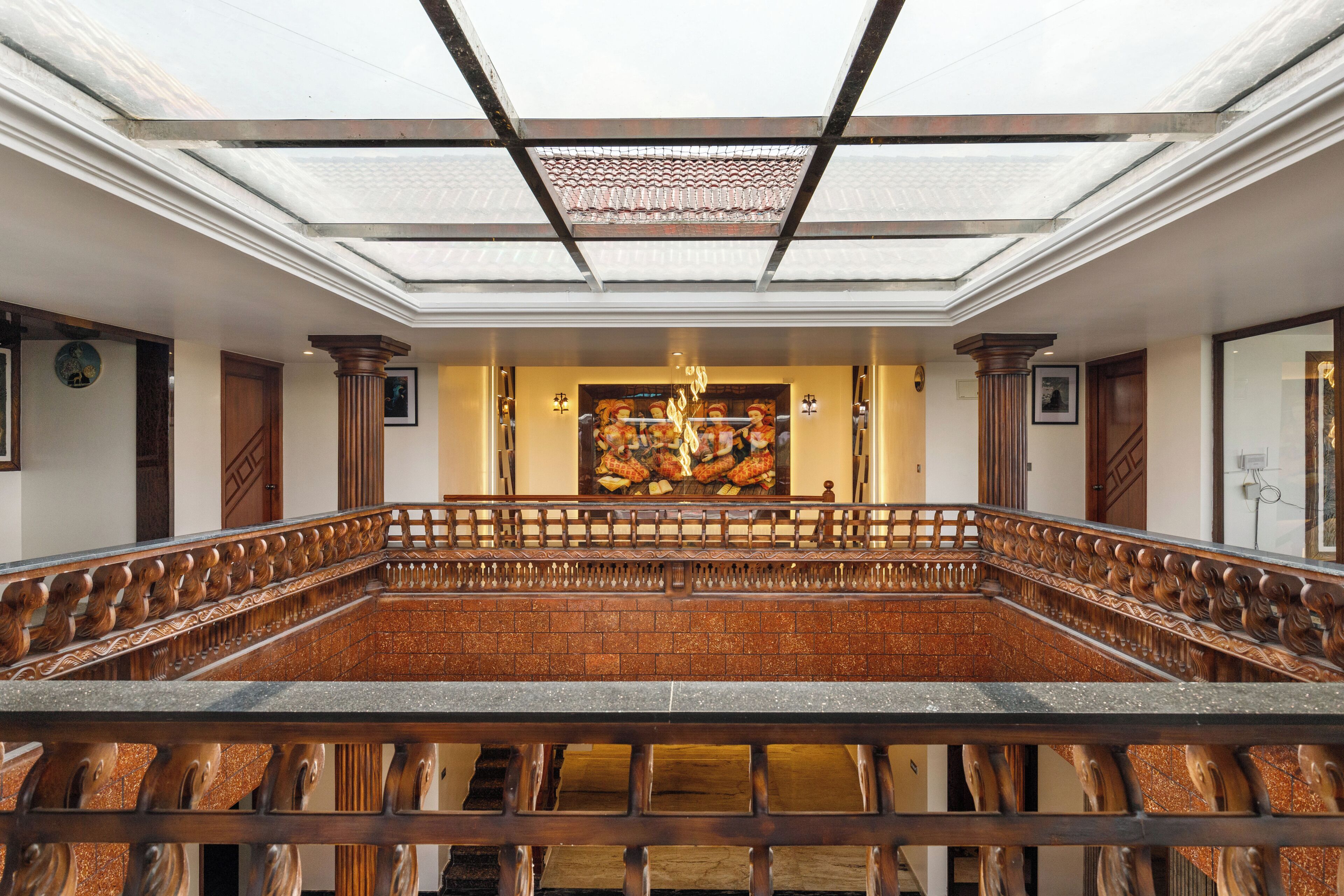 A spacious atrium with a high ceiling, a central fire feature, and a view of the kitchen area.