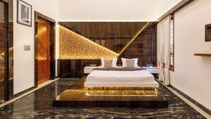 Une chambre d’hôtel moderne avec un grand lit, un mur décoratif en bois et un sol en marbre.