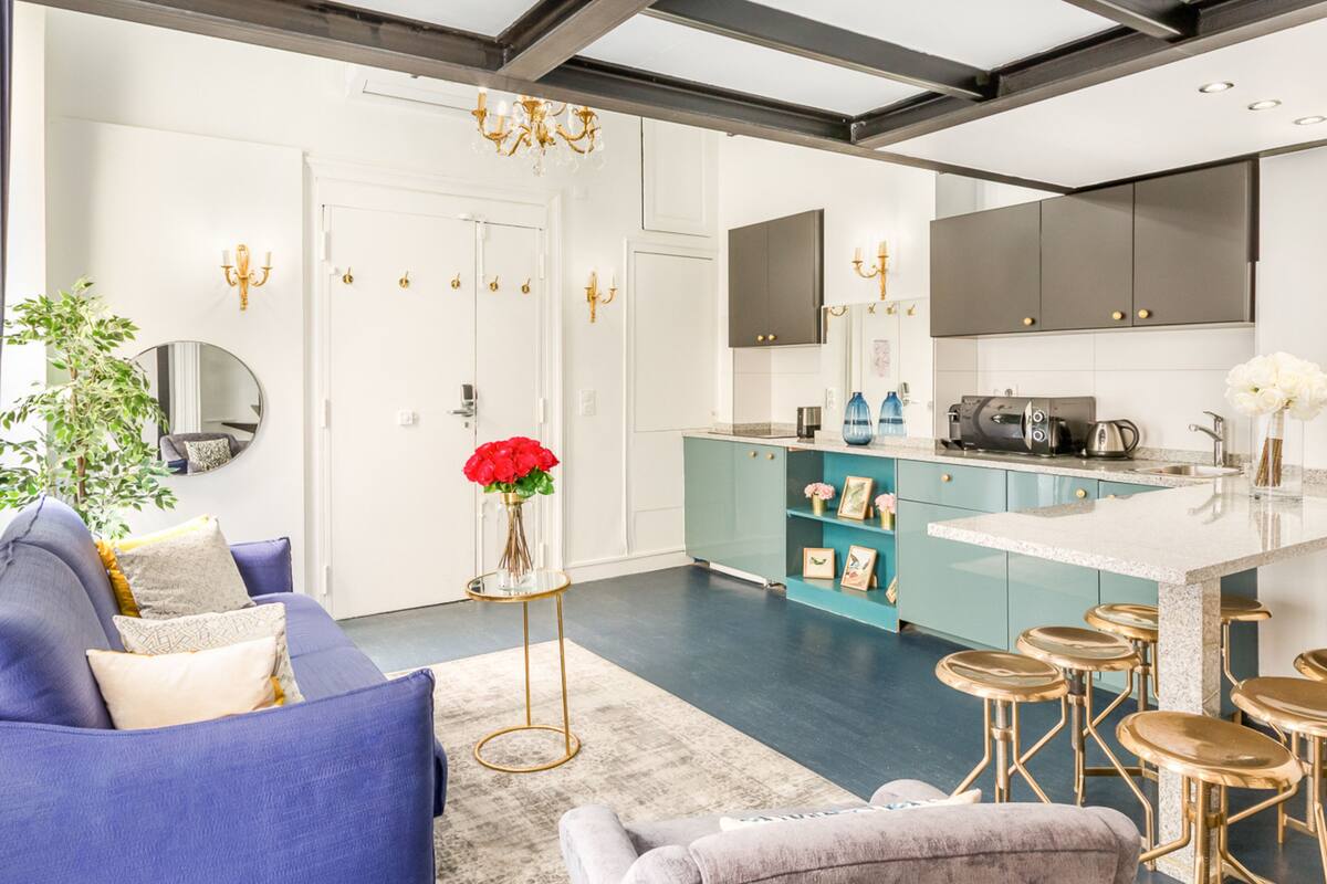 Una cocina moderna con armarios color turquesa, una isla central y taburetes de bar.