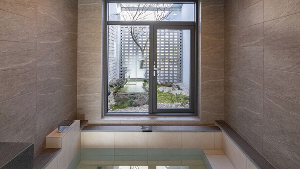 A modern bathroom with a wooden ceiling, a large window, and a built-in bathtub. - Gobajinin Private Pool Villa (Jeju City)