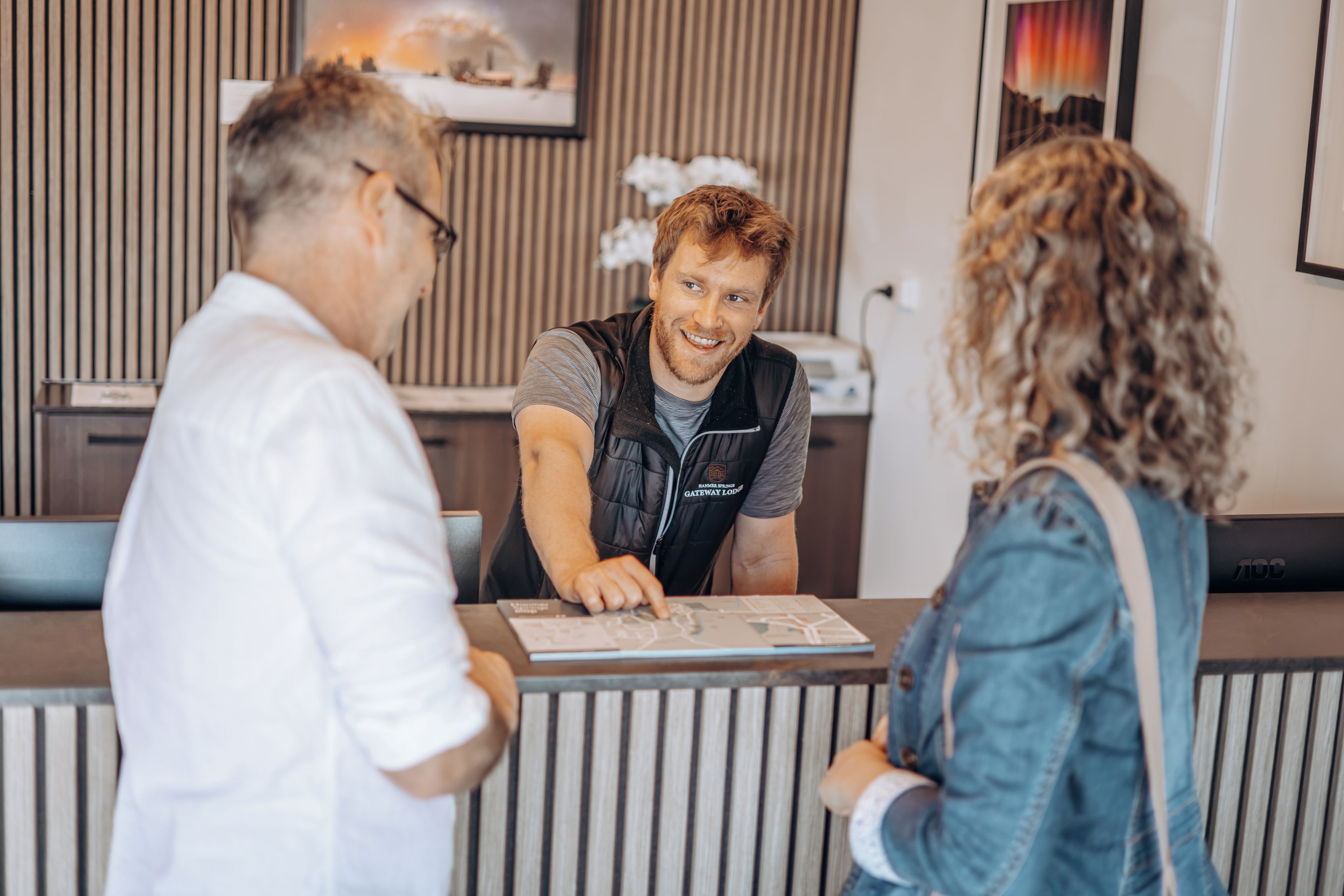 En reception med en mand i vest og en kvinde med krøller foran.