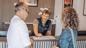 En reception med en mand i vest og en kvinde med krøller foran.