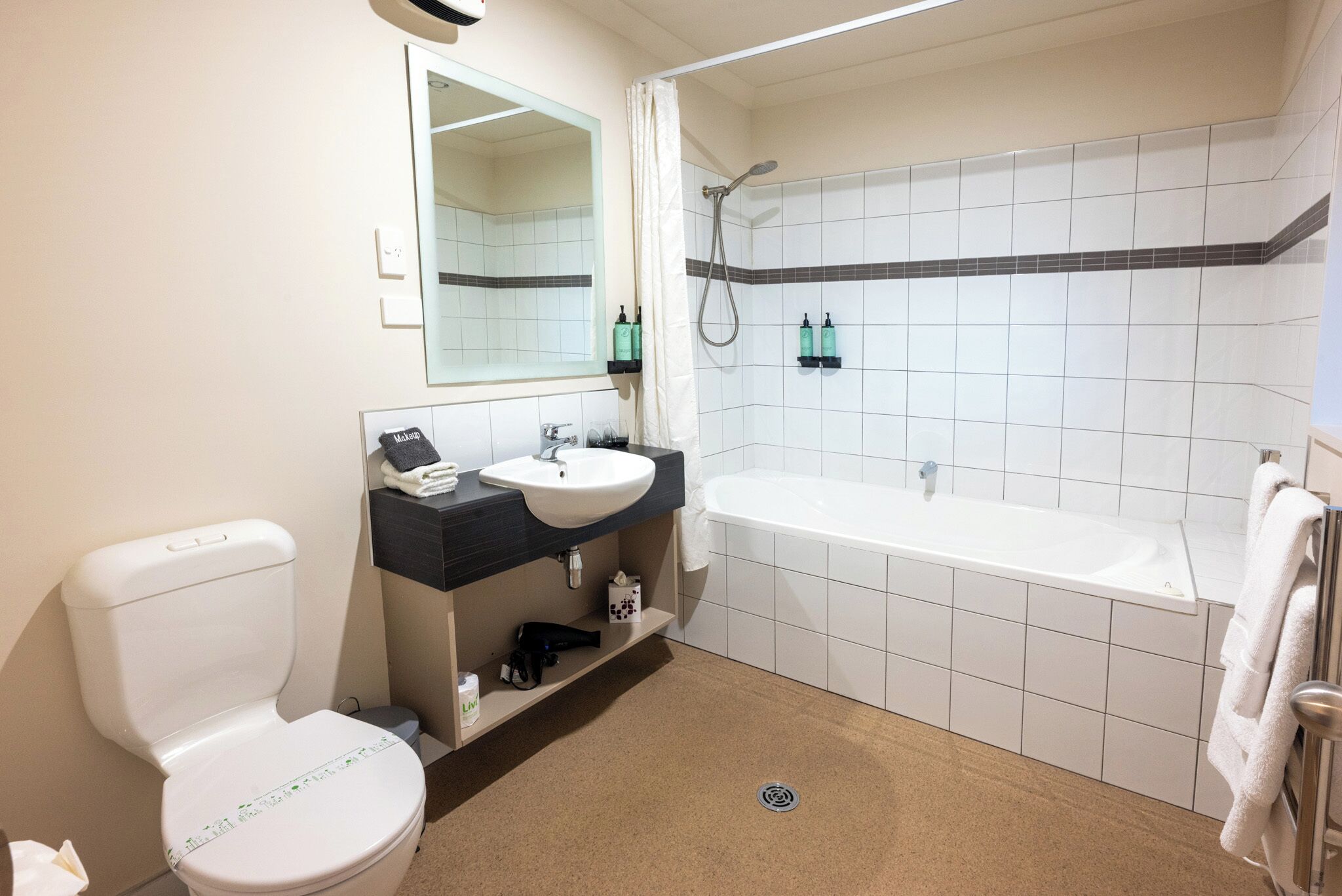 A bathroom with a toilet, sink, mirror, shower, and bathtub.
