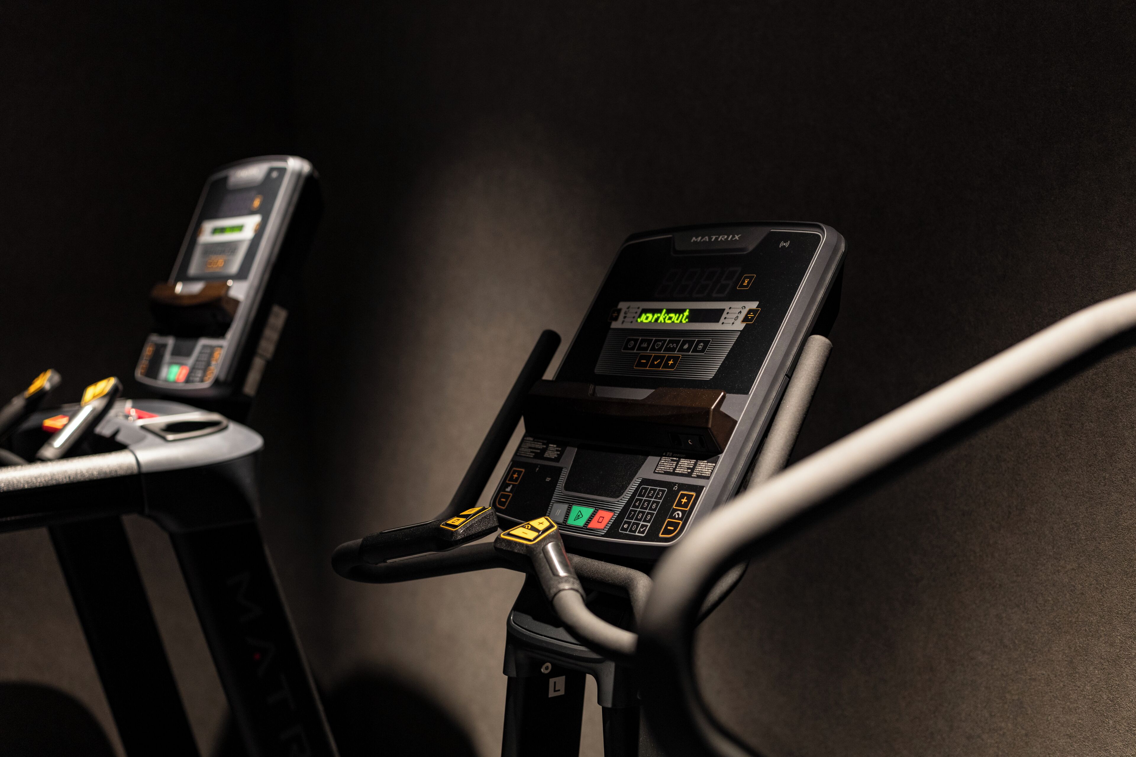 Exercise machines with digital displays and control panels.