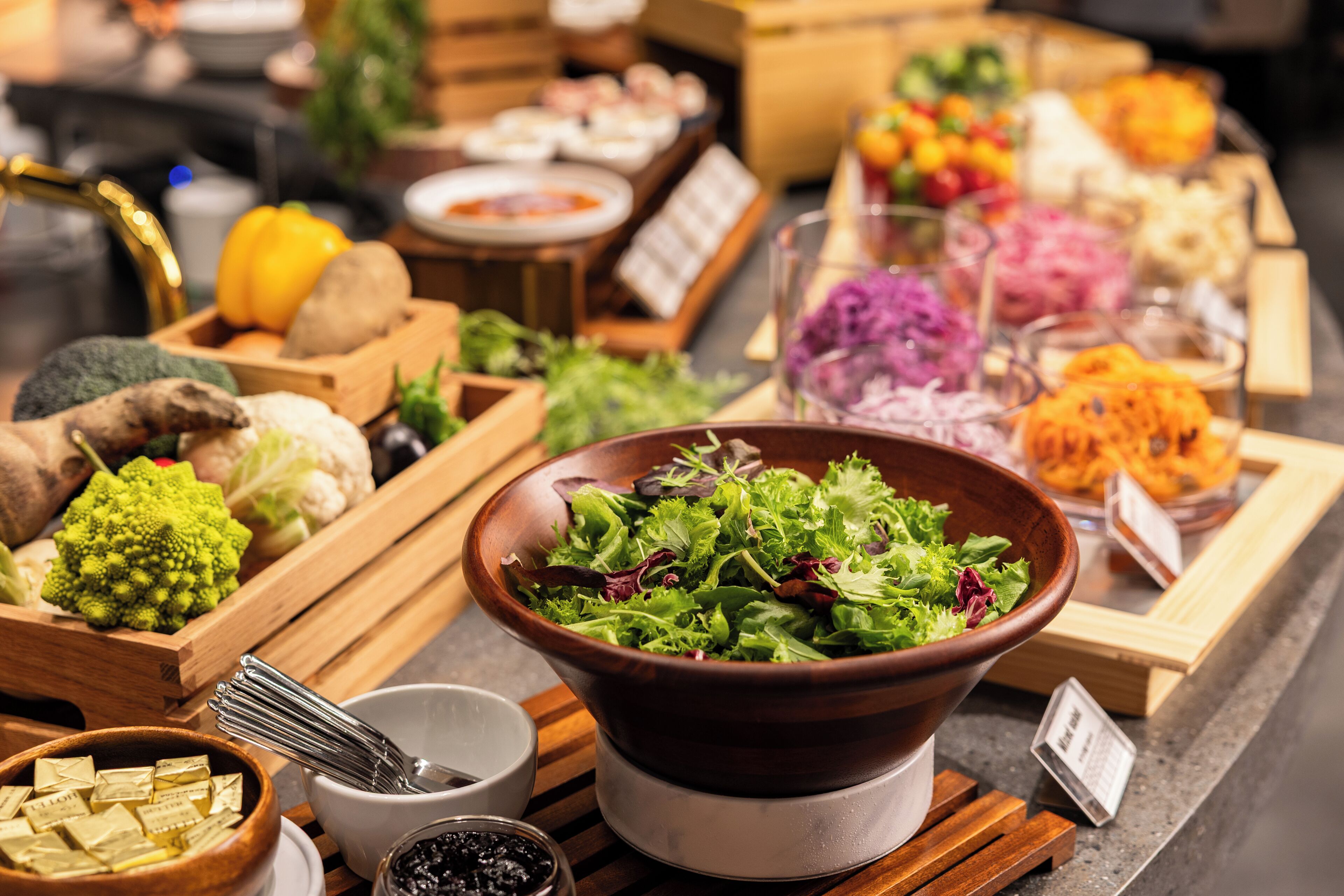 A buffet with various dishes including salads, vegetables, and seafood.
