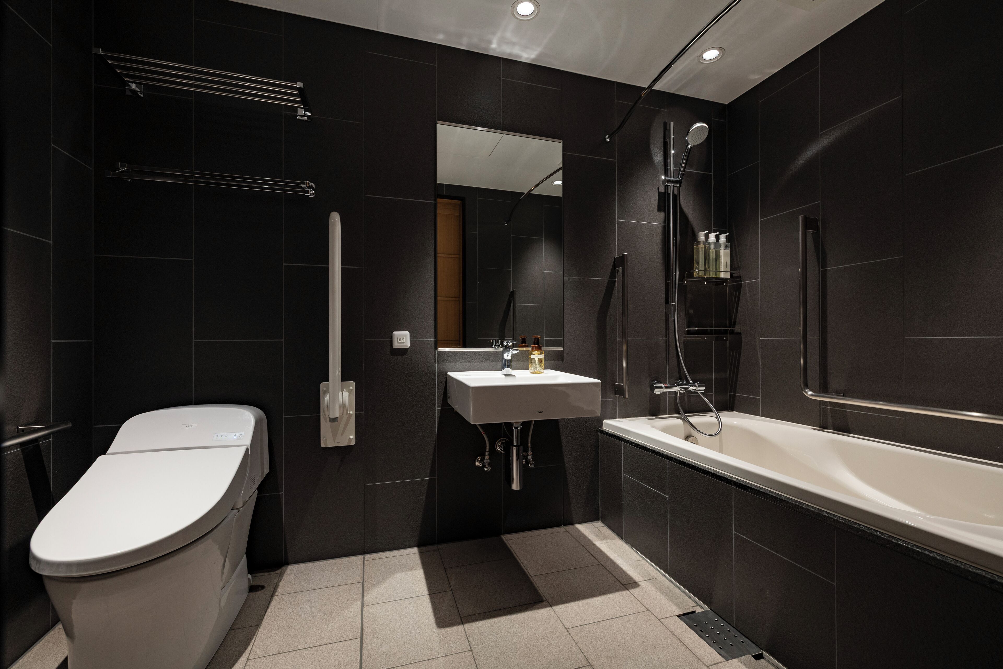 A modern bathroom with a toilet, sink, and bathtub.