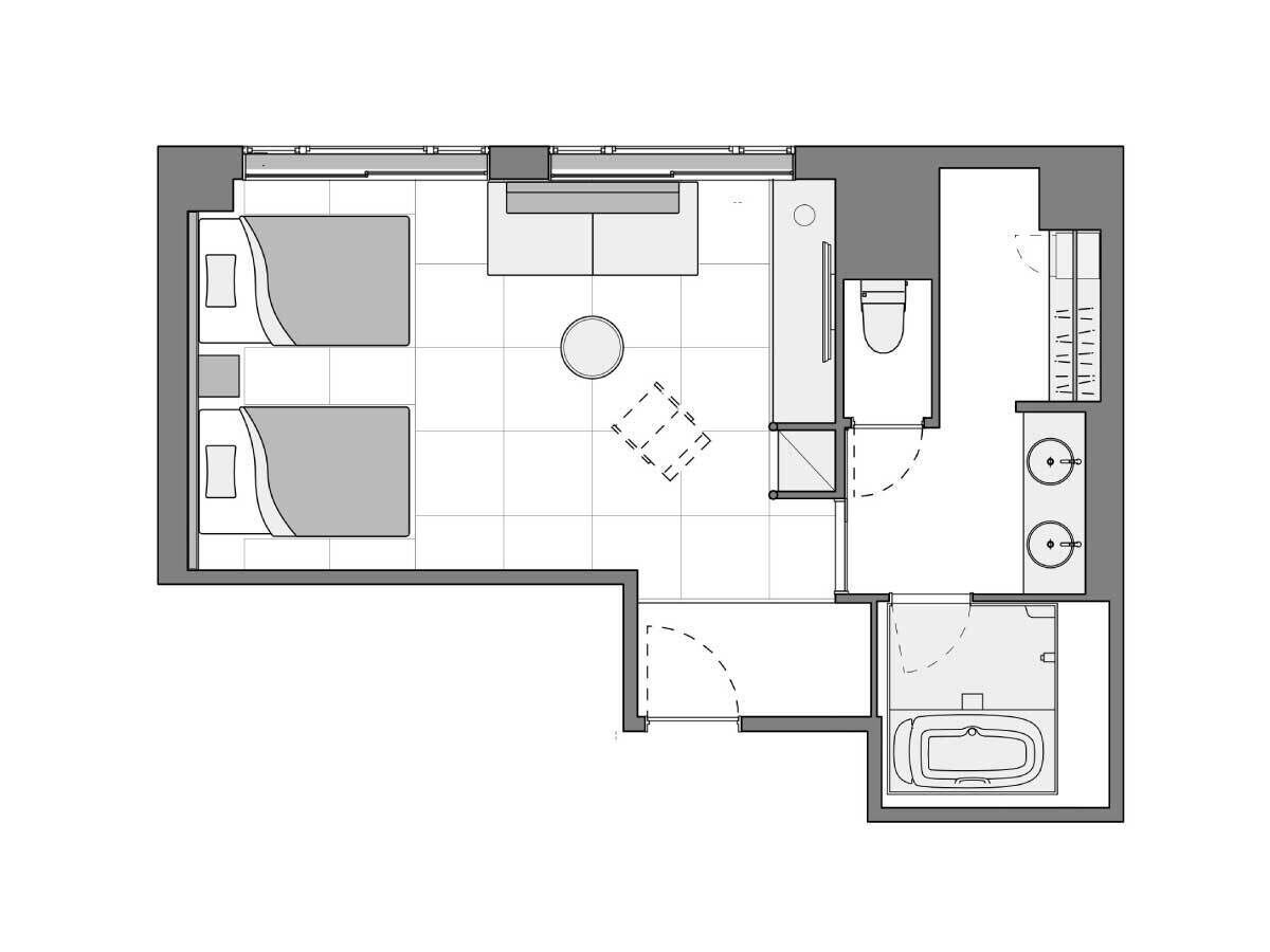 Indeling van een hotelkamer met een bed, een zithoekje, een badkamer en een kitchenette.