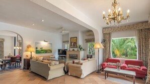 A spacious living room with a fireplace, a television, and a dining area with a table and chairs.
