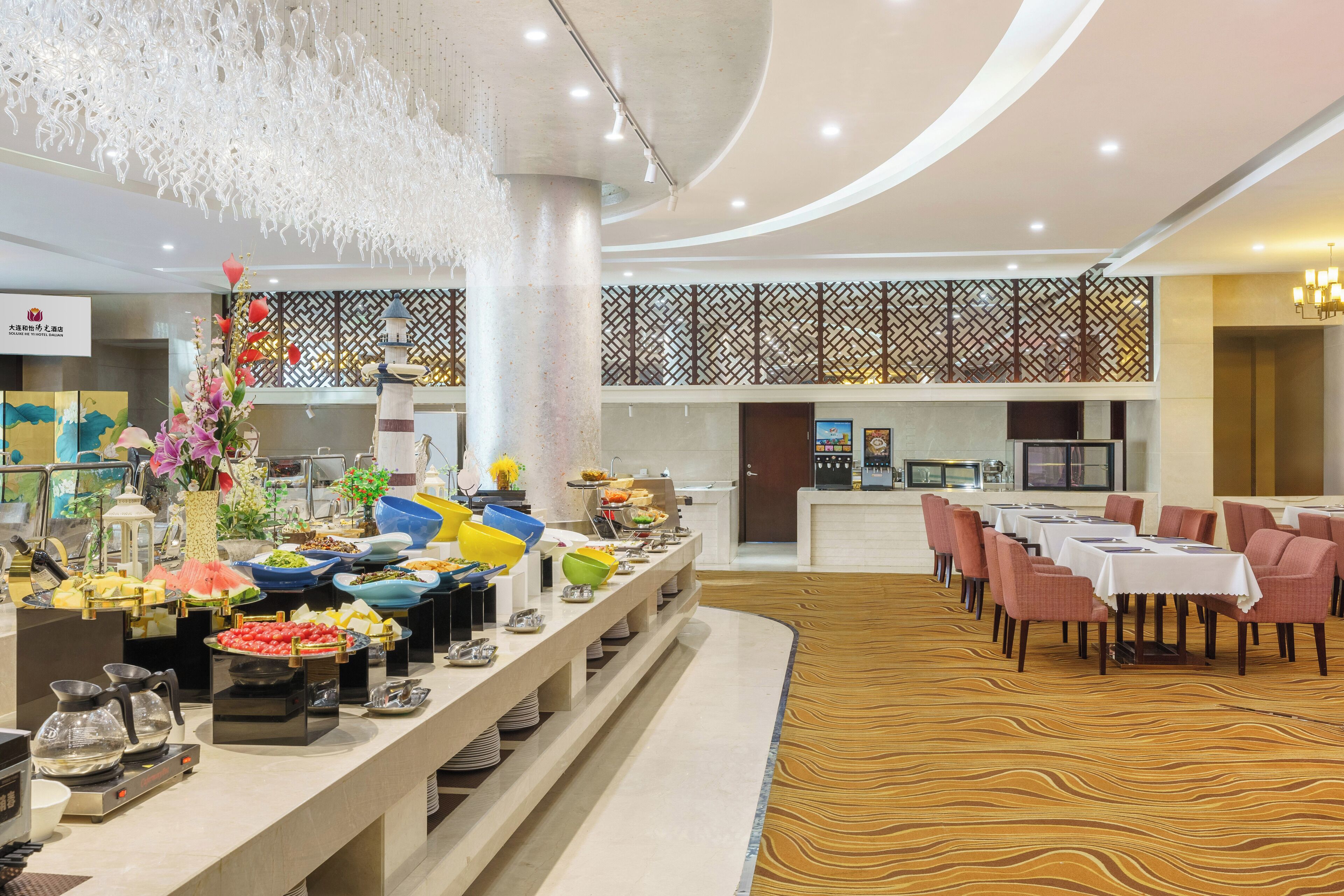 A buffet area with various food items and a seating area with tables and chairs.