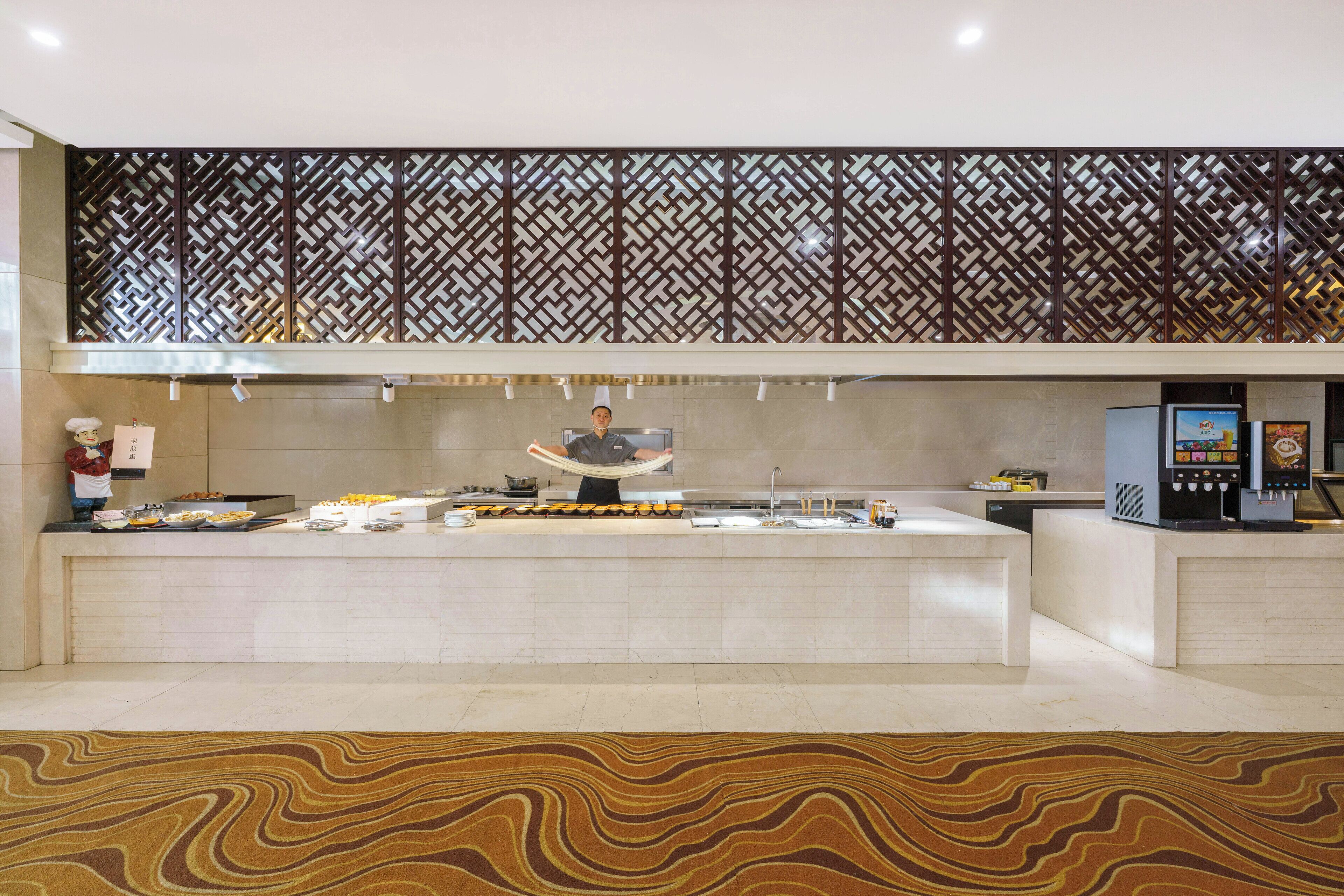 A modern kitchen with a buffet setup, a decorative wall, and a patterned floor.