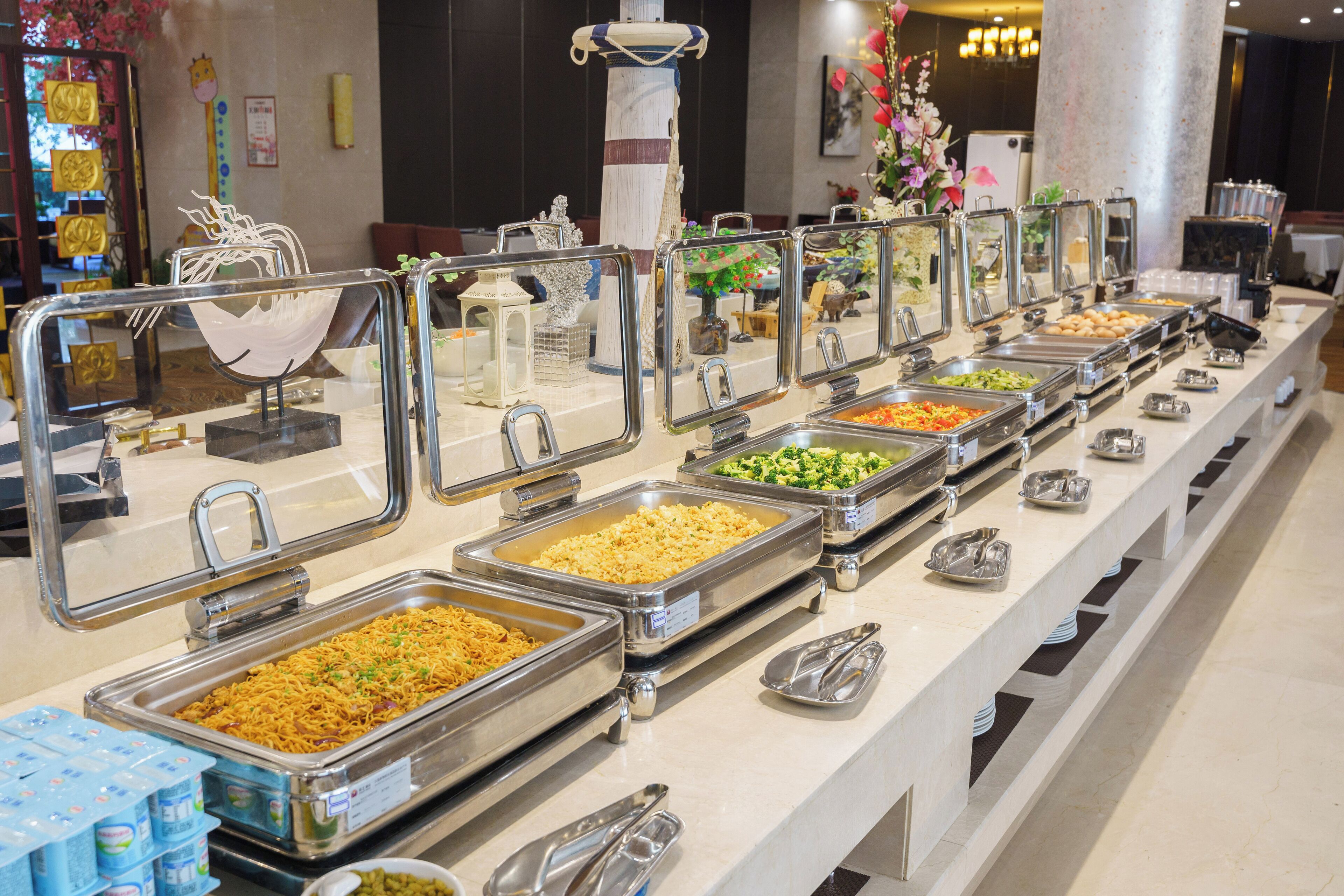 Un buffet proposant une variété de plats et d’ustensiles de service.