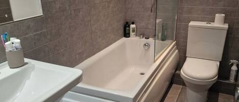 A modern bathroom with a bathtub, toilet, and sink.