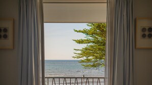 A bedroom with a view of the sea through a balcony. - Lusa Beach Studios (Banjar)