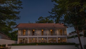 A two-story building with a red-tiled roof, multiple balconies, and a well-lit facade. - Lusa Beach Studios (Banjar)