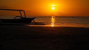 A beach scene with a boat and a sunset. - Lusa Beach Studios (Banjar)