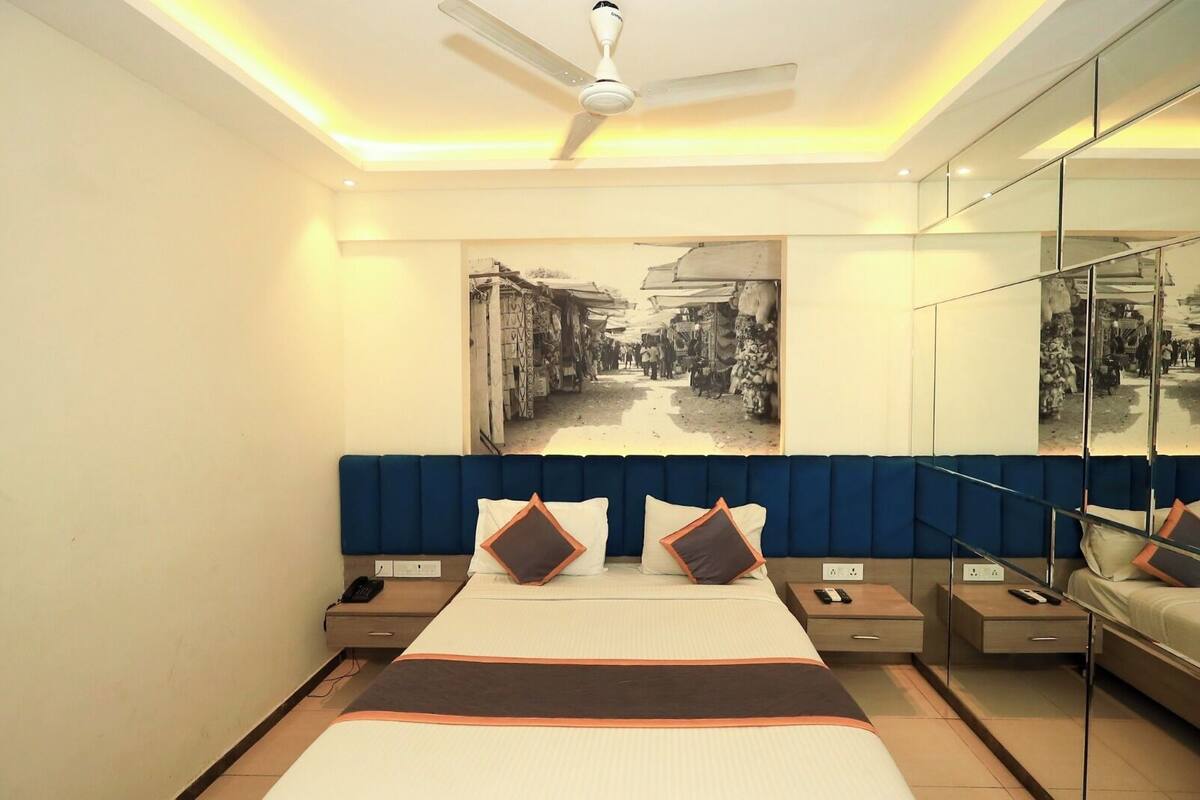 Een moderne slaapkamer met een groot bed, een plafondventilator en kunst aan de muur.