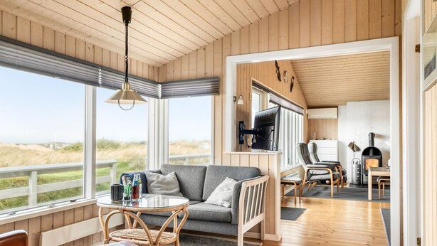Interior acogedor de una cabaña con sala de estar, comedor y chimenea.