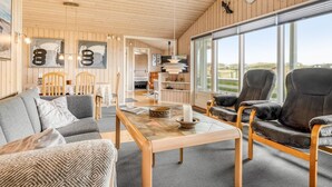 Un interior moderno con paneles de madera, un comedor y un amplio ventanal con vistas.