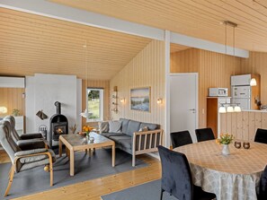 Uma sala de estar moderna com lareira, sofá e área de refeições.