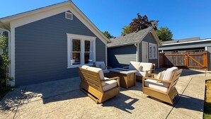Ett hus med en täckt uteplats, utemöbler och ett garage.