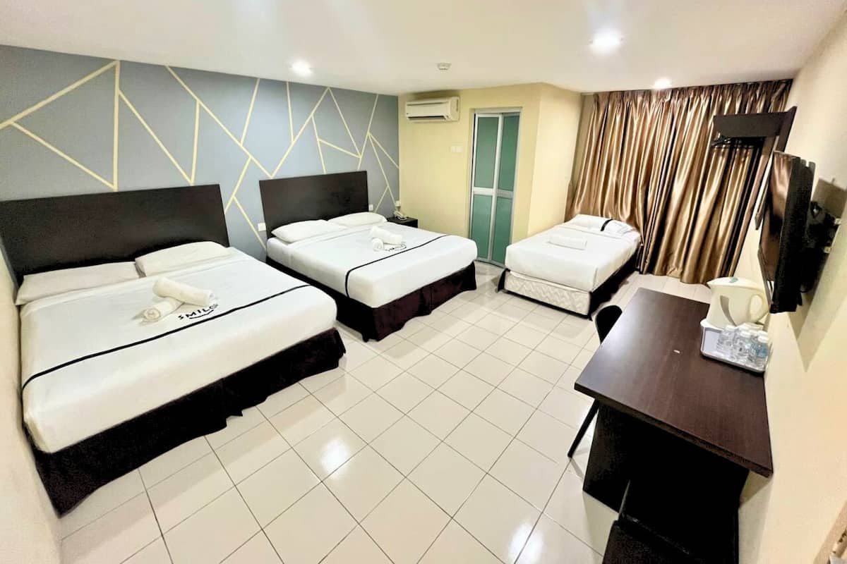 A hotel room with two beds, a desk, and a chair.