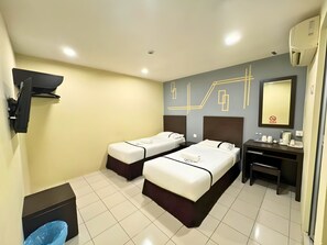 Quarto de hotel com duas camas, uma escrivaninha, uma cadeira, uma televisão e um espelho.