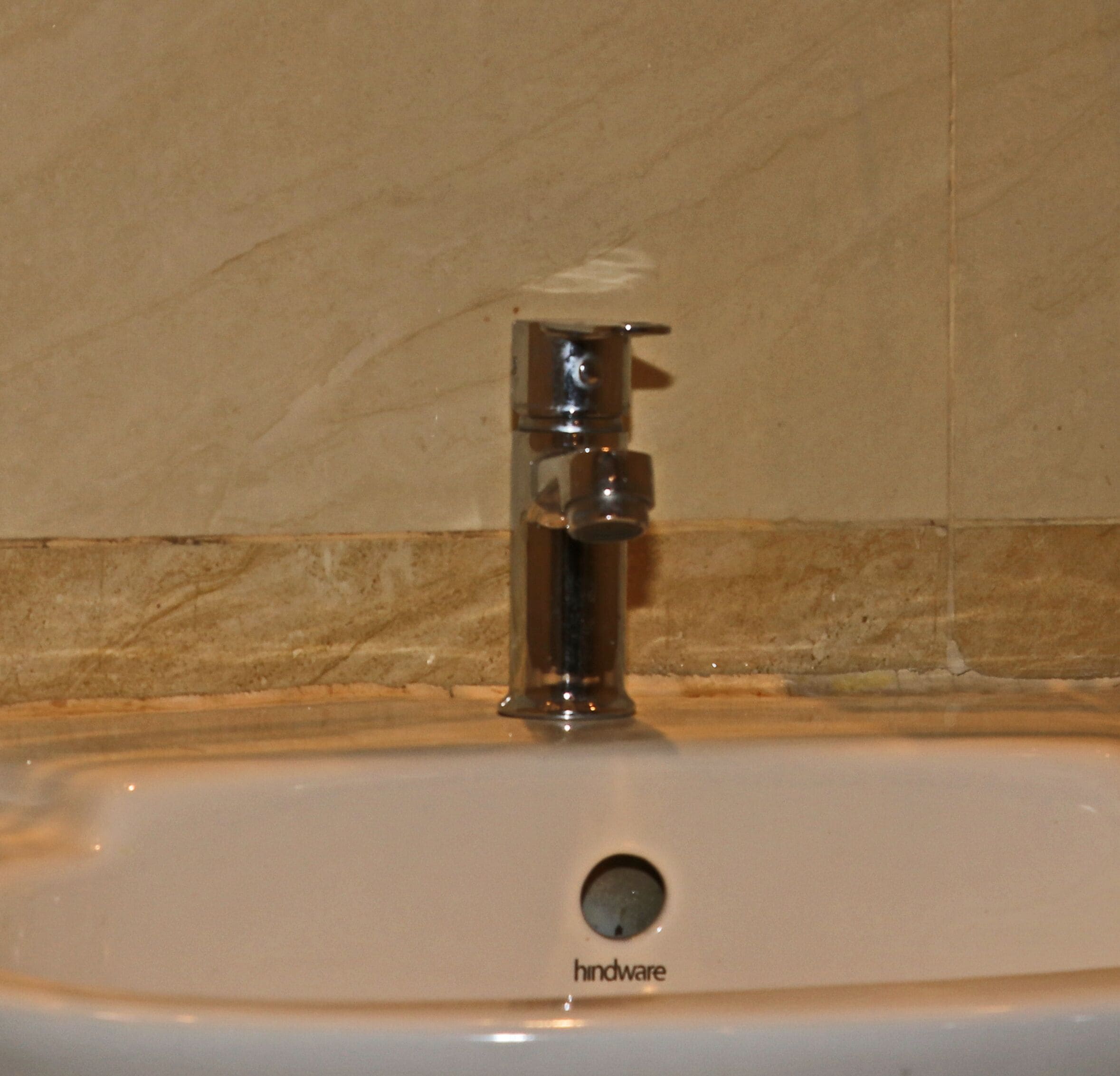 Un lavamanos con grifo cromado y desagüe visible.