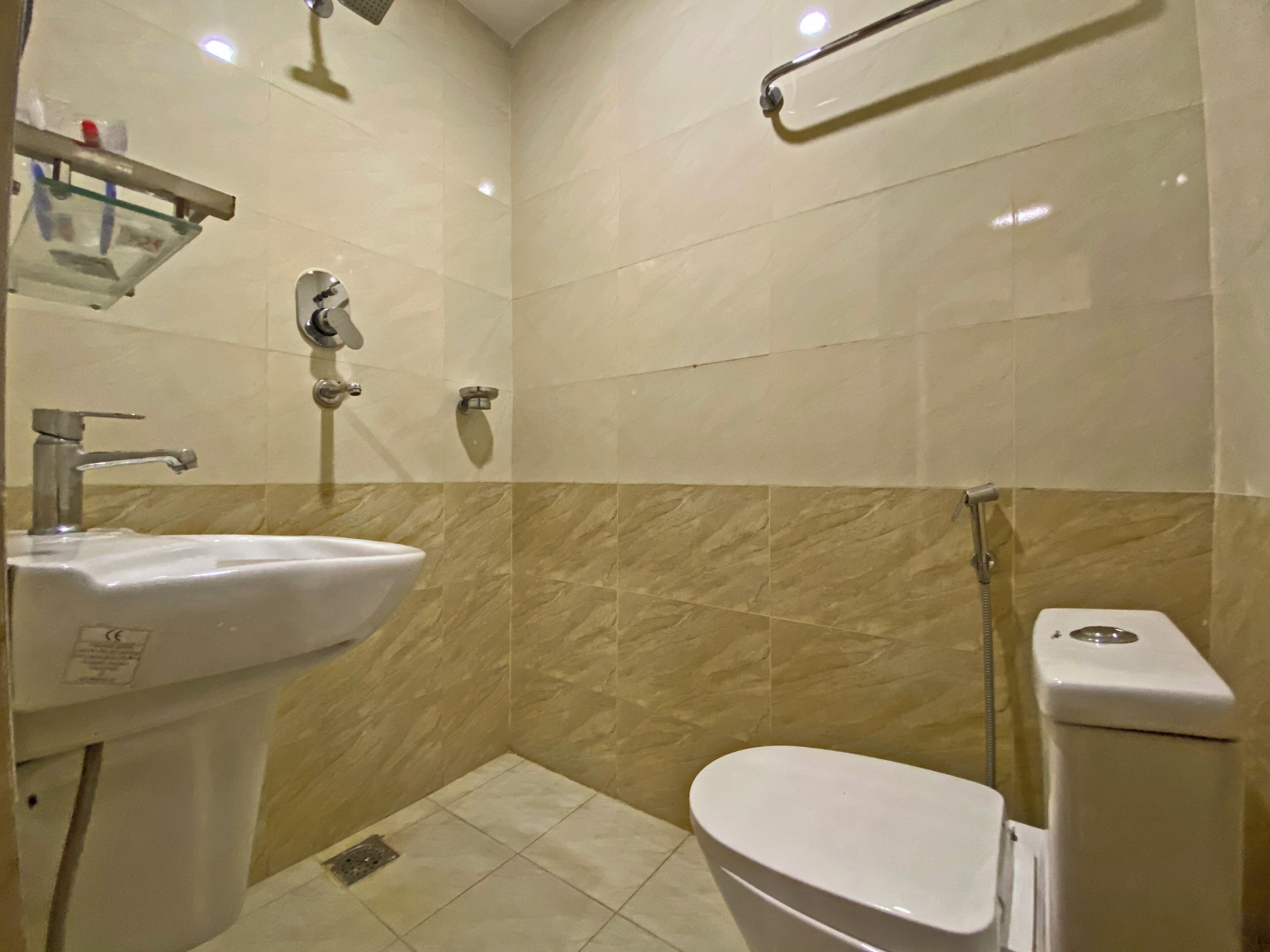 Un bagno moderno e piccolo, con lavandino, servizi igienici e doccia.